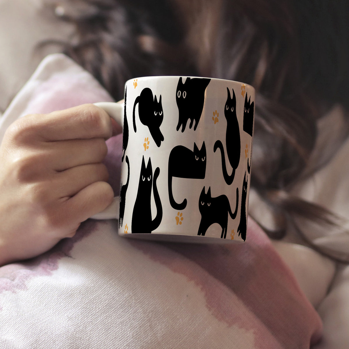 Woman holding a mug with black cat pattern
