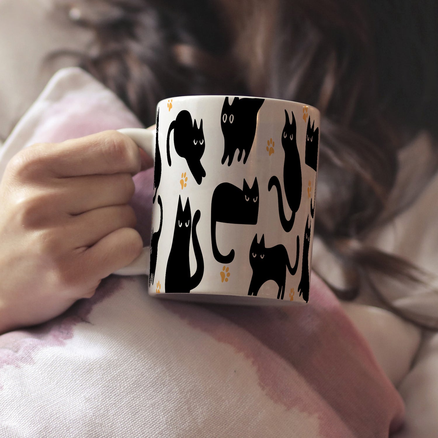 Woman holding a mug with black cat pattern