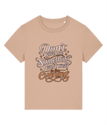 A beige short-sleeve t-shirt with a graphic text print on the front that reads 'Don't give me something I can't wear in the evening' in stylized brown and white lettering with small star accents, shown on a plain white background.