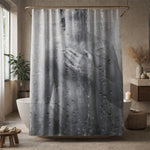A shower curtain with a black-and-white print of a man showering, partially obscured by water droplets, hangs in a modern bathroom with a freestanding tub, plants, and neutral-colored decor.