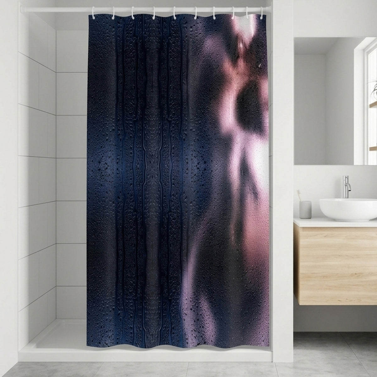 A shower curtain with a design showing a blurred, artistic silhouette of a person behind steamy, water-dappled glass, hanging in a modern white bathroom with a wooden vanity and a window.