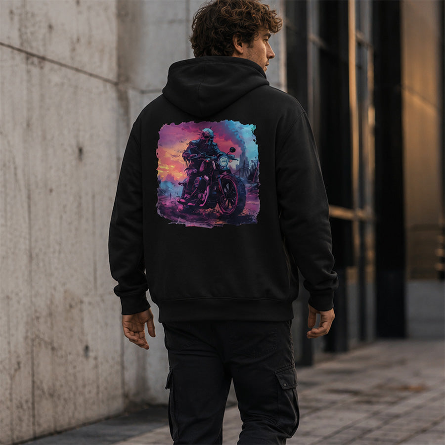 A man viewed from behind wearing a black hoodie with a large colorful graphic print of a motorcycle rider on the back, set in an urban alleyway.