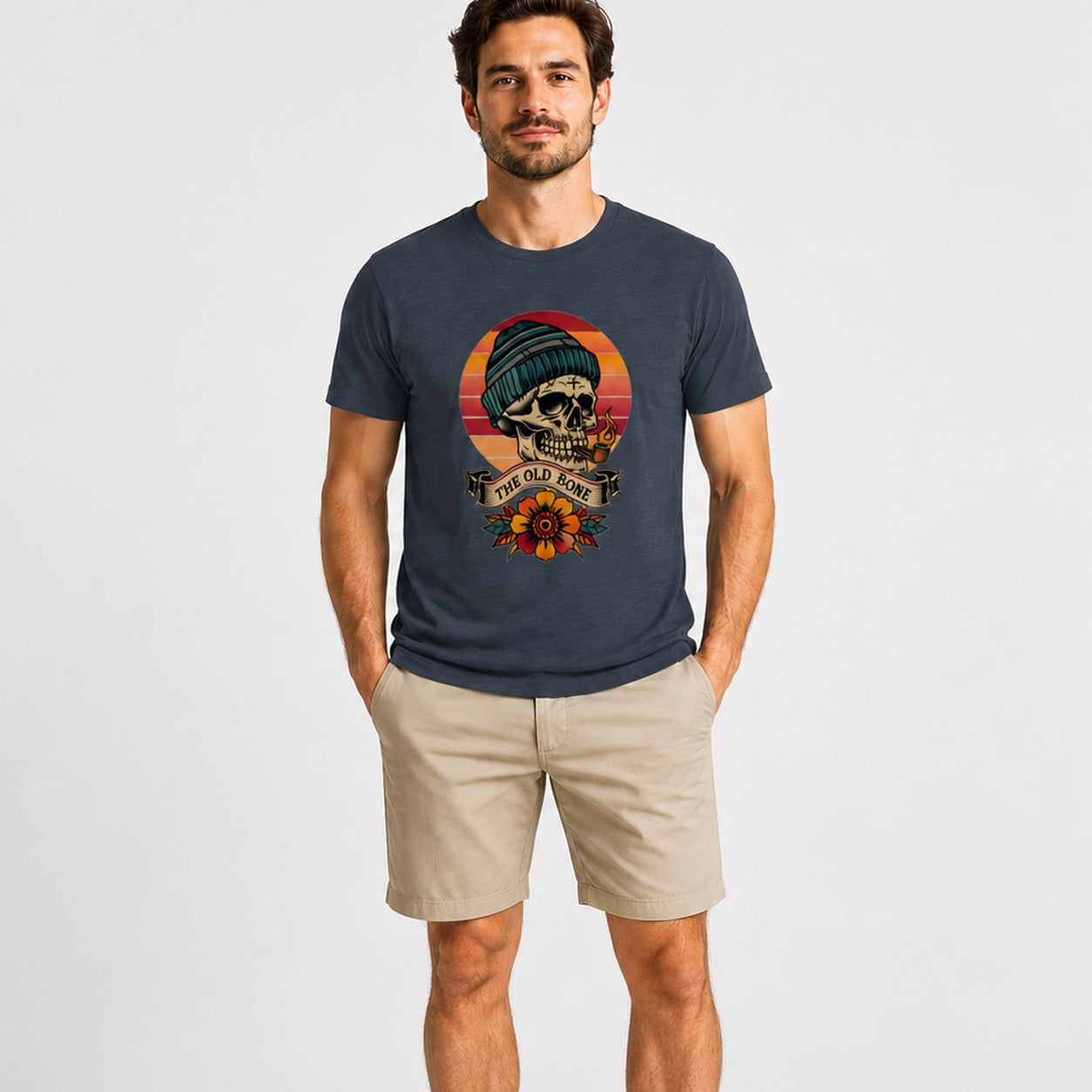 Man wearing a navy blue t-shirt with a skull graphic design on a plain background