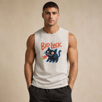 A muscular man wearing a sleeveless white tank top with a graphic of a black cat and the text 'BAD LUCK' in red, paired with dark gray pants, standing against a beige background.