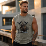 A muscular man wearing a gray sleeveless t-shirt with a Viking warrior graphic print, standing outdoors on a balcony with a blurred modern building background.