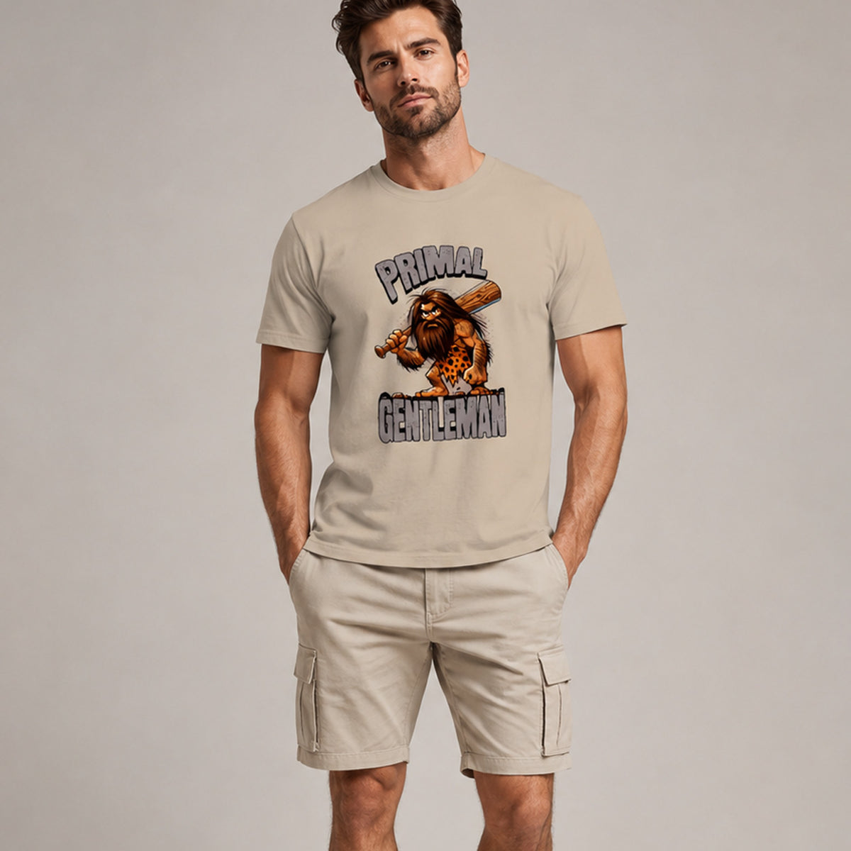 Man wearing a beige t-shirt with 'Primal Gentleman' graphic design on a plain background
