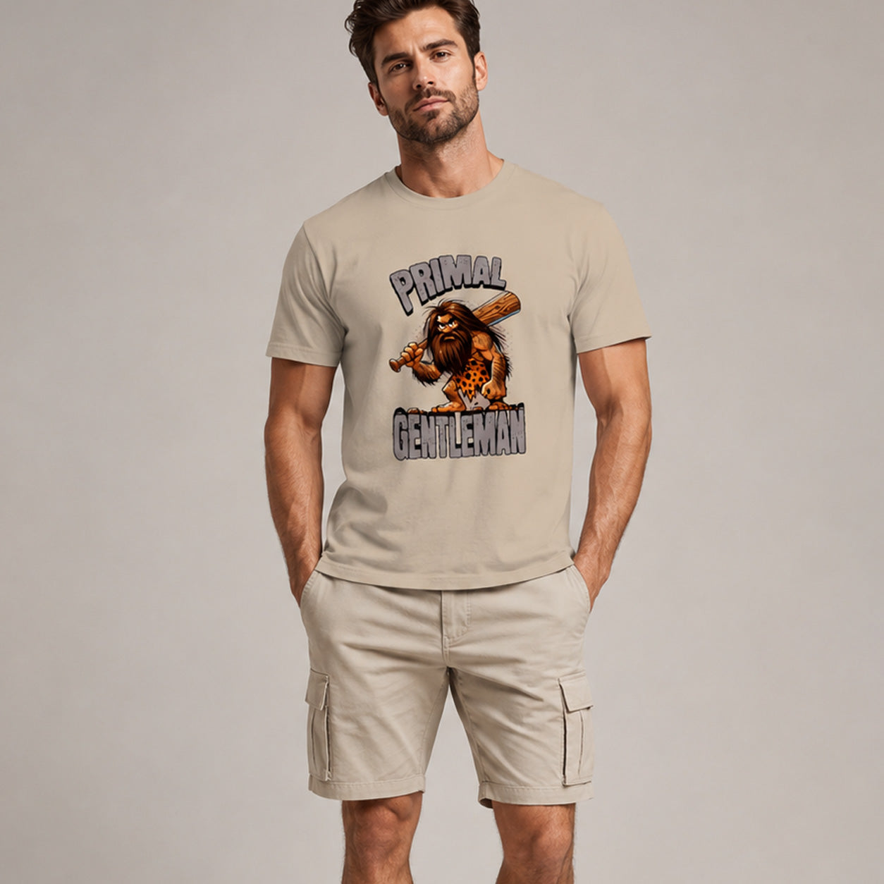 Man wearing a beige t-shirt with 'Primal Gentleman' graphic design on a plain background