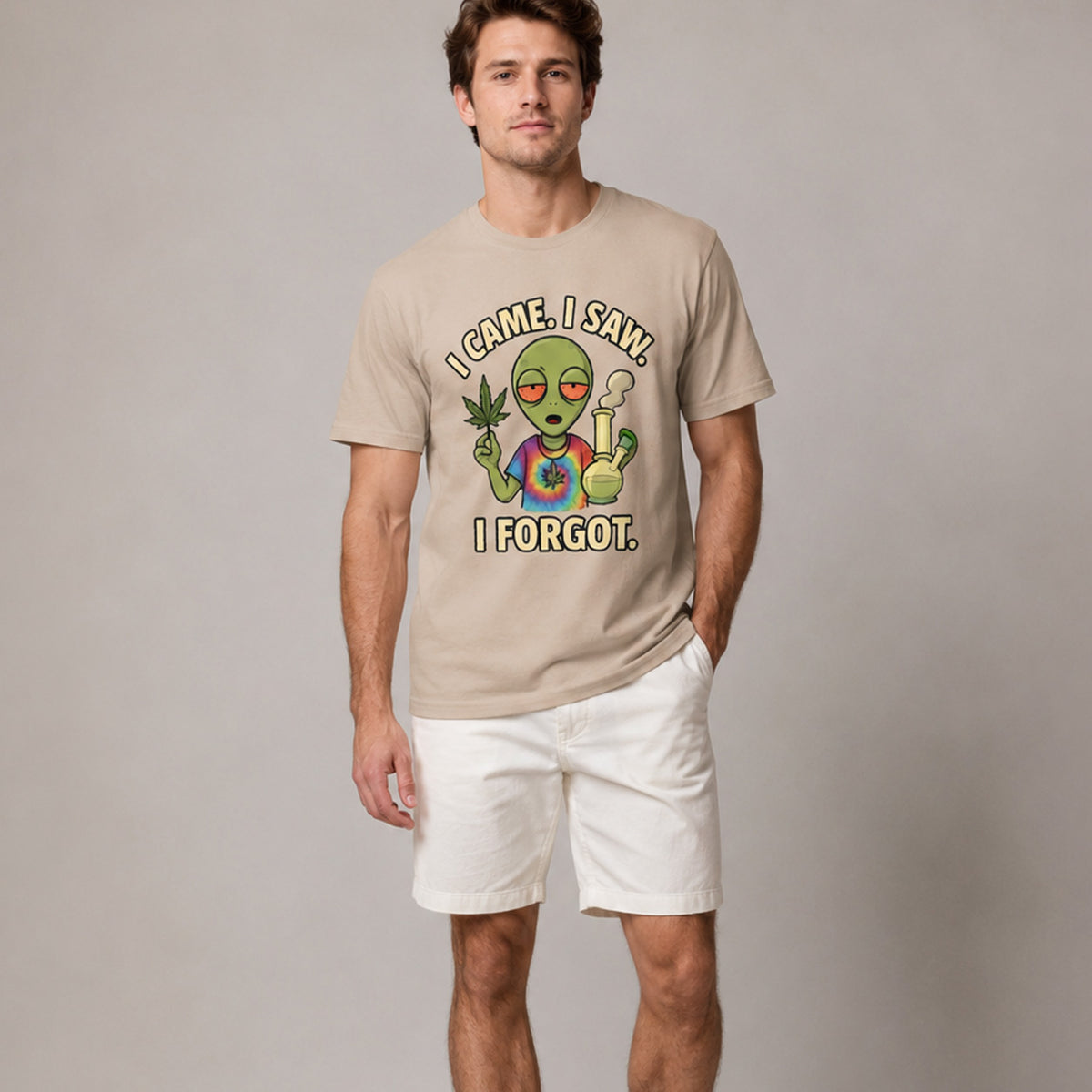 Man wearing a beige t-shirt with an alien graphic and text on a plain background