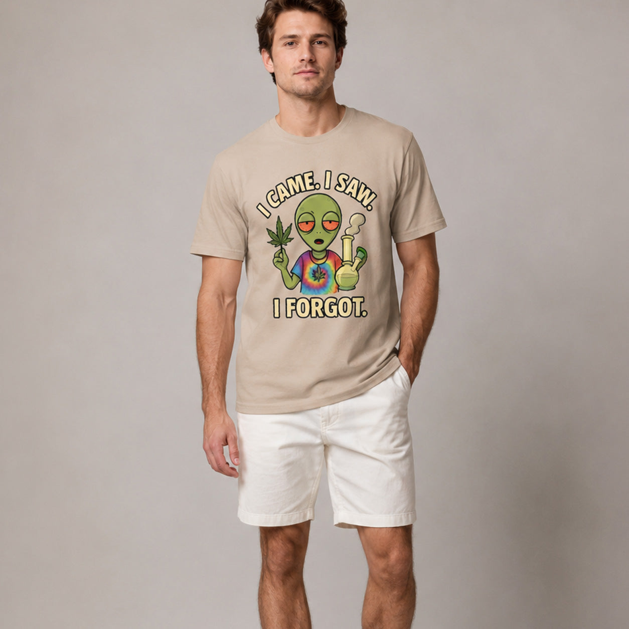Man wearing a beige t-shirt with an alien graphic and text on a plain background