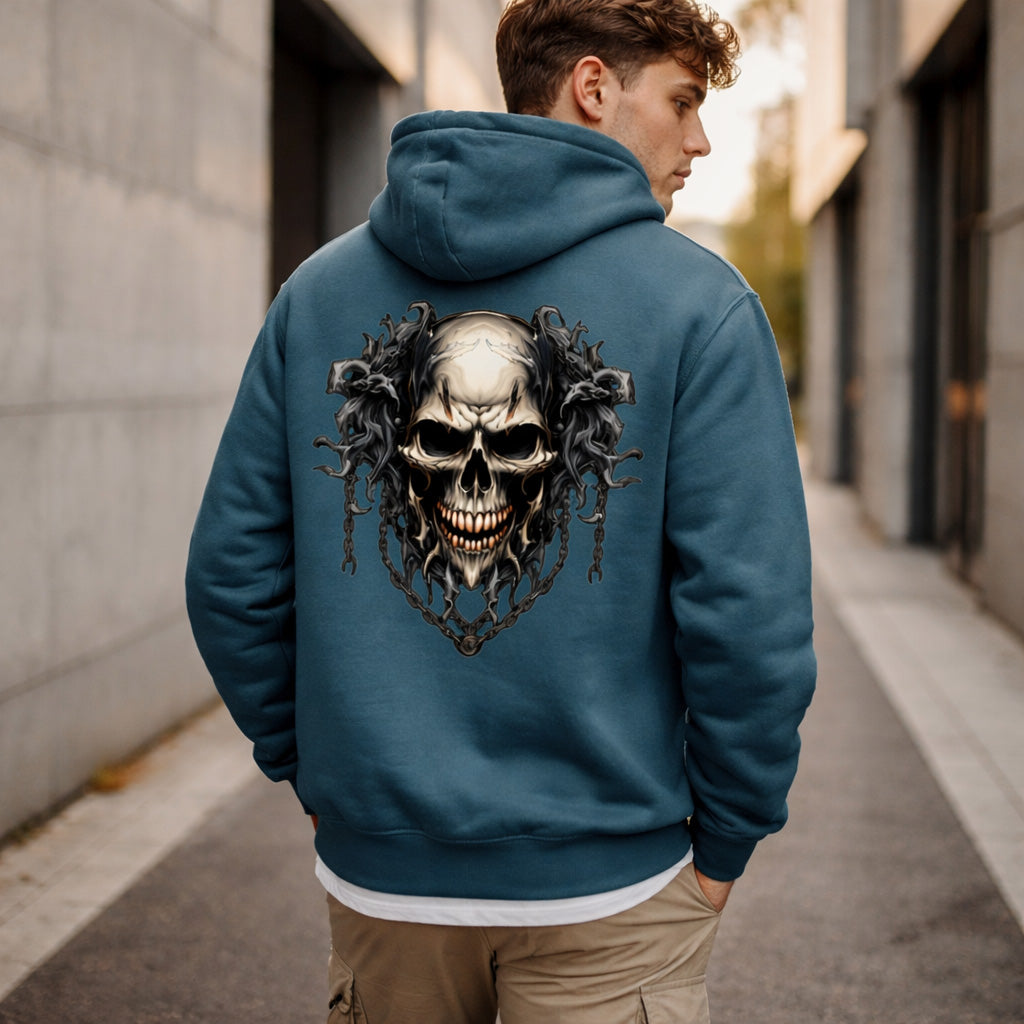 A man wearing a blue hoodie with a large graphic of a menacing skull and dark, swirling designs on the back walks down a city sidewalk.