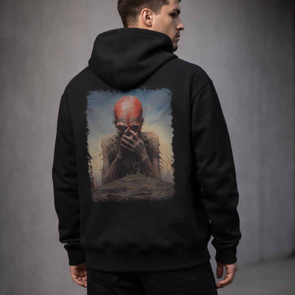 A man wearing a black hoodie stands with his back to the camera. The hoodie features artwork of a red-skinned, eerie humanoid figure covering its mouth amid a dark, surreal landscape.
