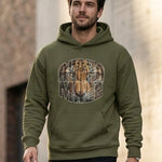 Man wearing a green hoodie with a graphic design in an urban setting