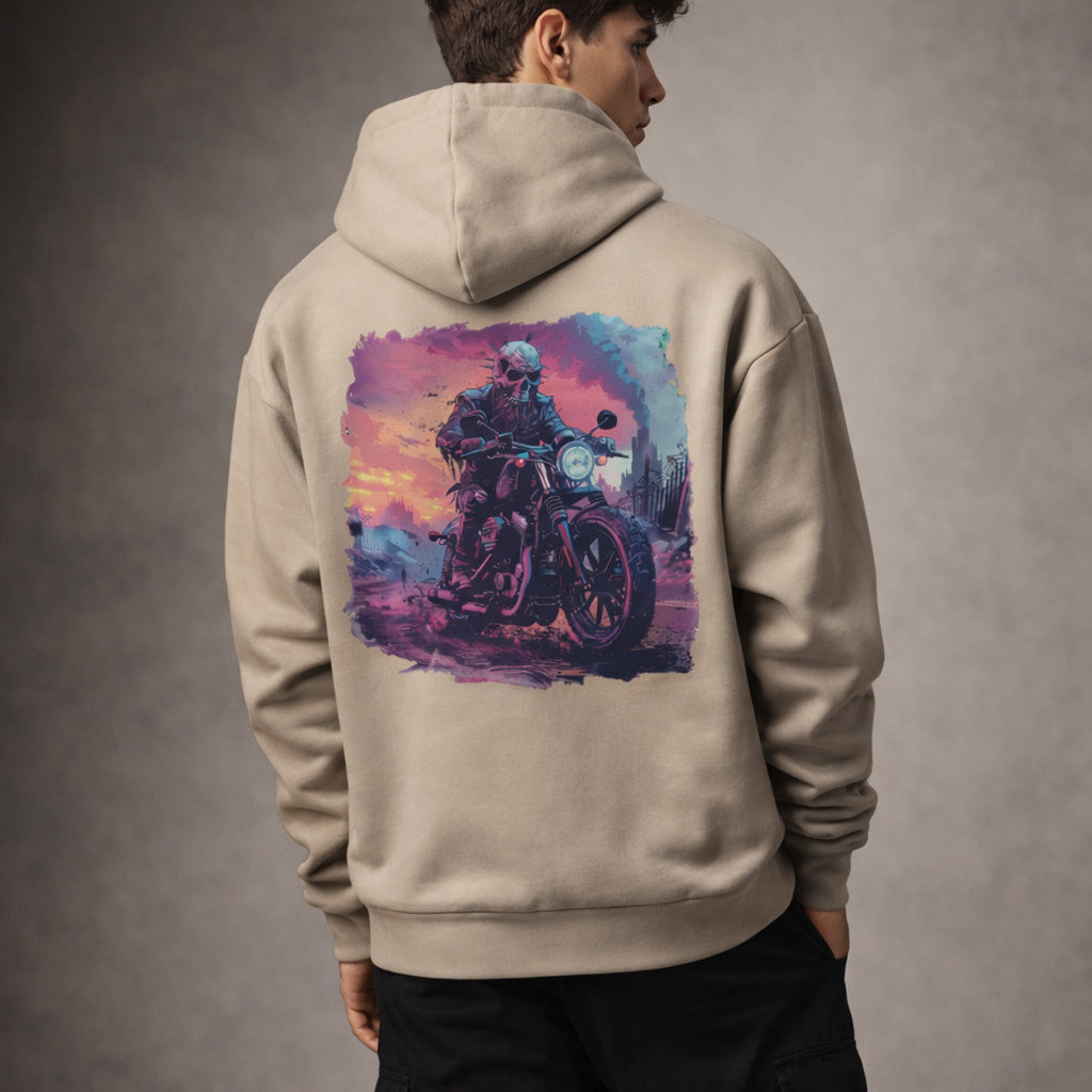 Man Beige hoodie with a colorful graphic of a person on a motorcycle on the back, worn by a person against a gray background.