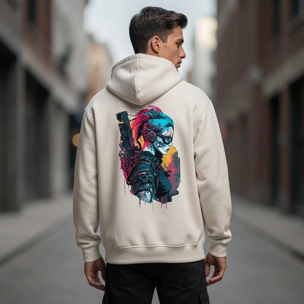 A young man stands in an urban alleyway wearing a light-colored hoodie with vibrant cyberpunk-style artwork of a futuristic woman and cityscape on the back.