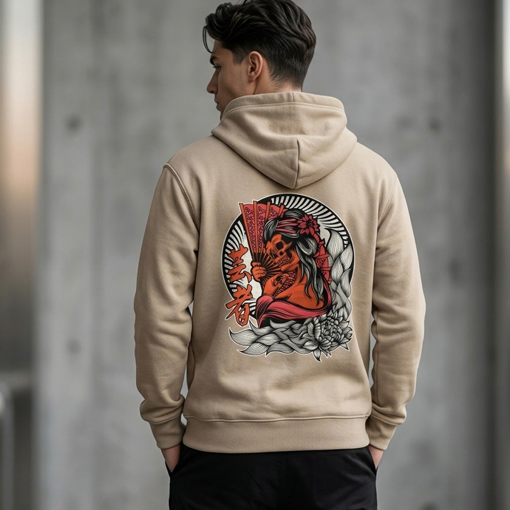 A man wearing a beige hoodie stands with his back to the camera. The hoodie features a large, colorful graphic of a geisha with fans and flowers on the back. The background is blurred and gray.