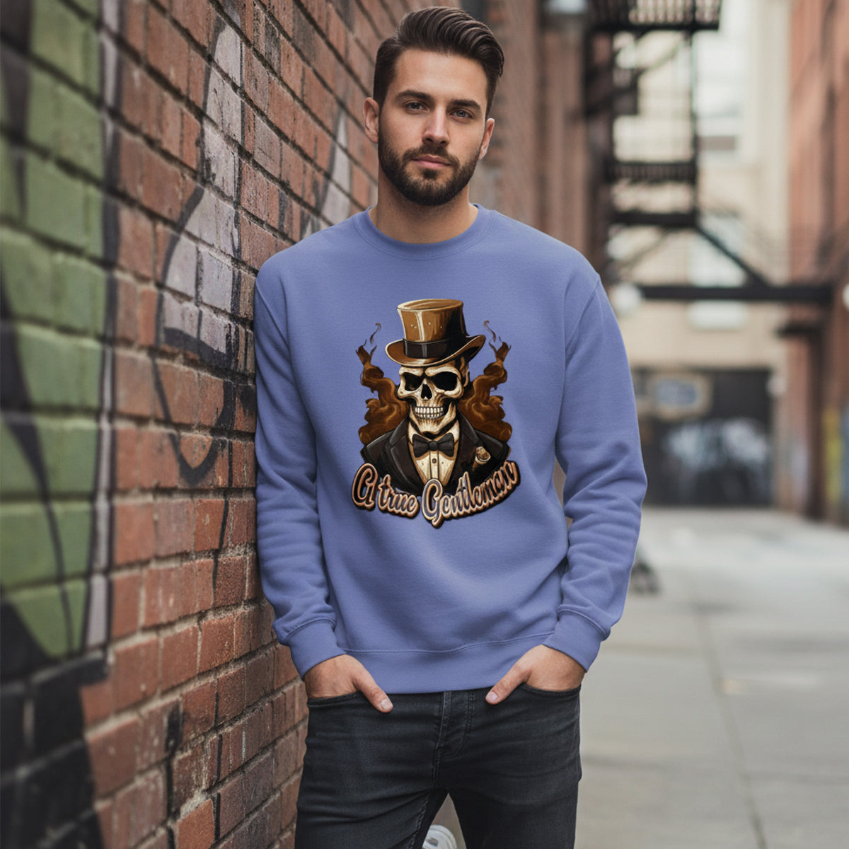 Man wearing a blue sweatshirt with a skull design leaning against a brick wall.
