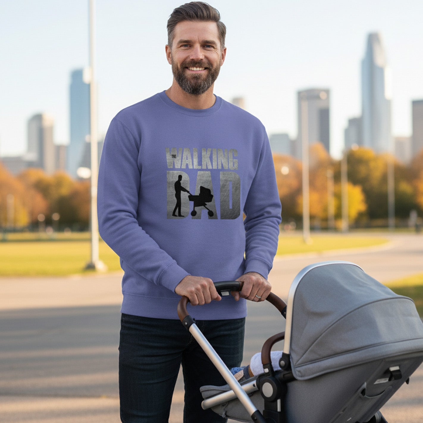 Man wearing a purple sweatshirt with 'Walking Dad' text, pushing a stroller in an urban park setting.