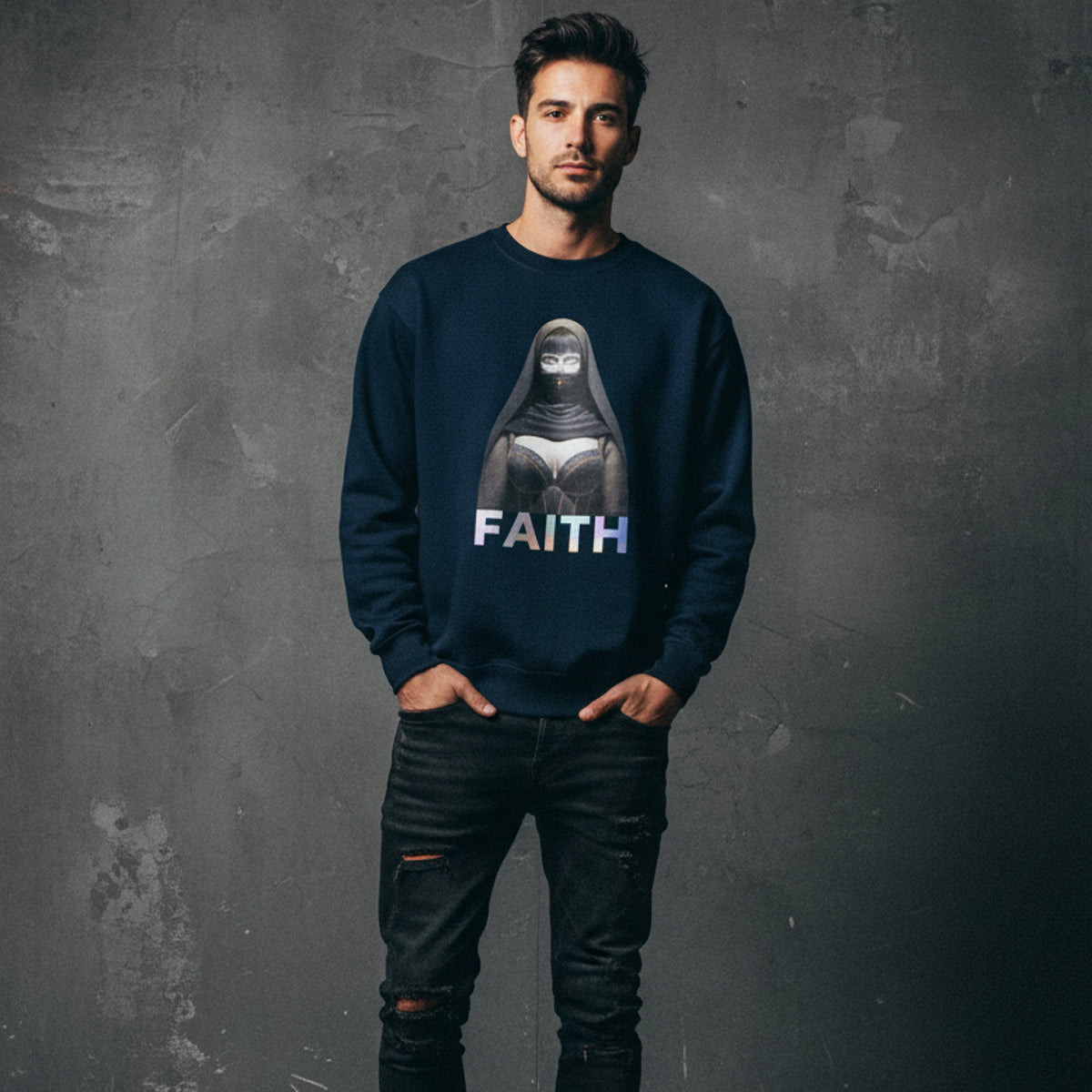A man stands against a textured gray wall, wearing a navy blue sweatshirt featuring an illustrated woman in a headscarf with the word "FAITH" printed below the image. He has his hands in his pockets and wears ripped black jeans.