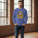 A smiling man stands indoors by large windows, wearing a blue sweatshirt that reads "There is always time for another beer" with beer mugs and a clock graphic.