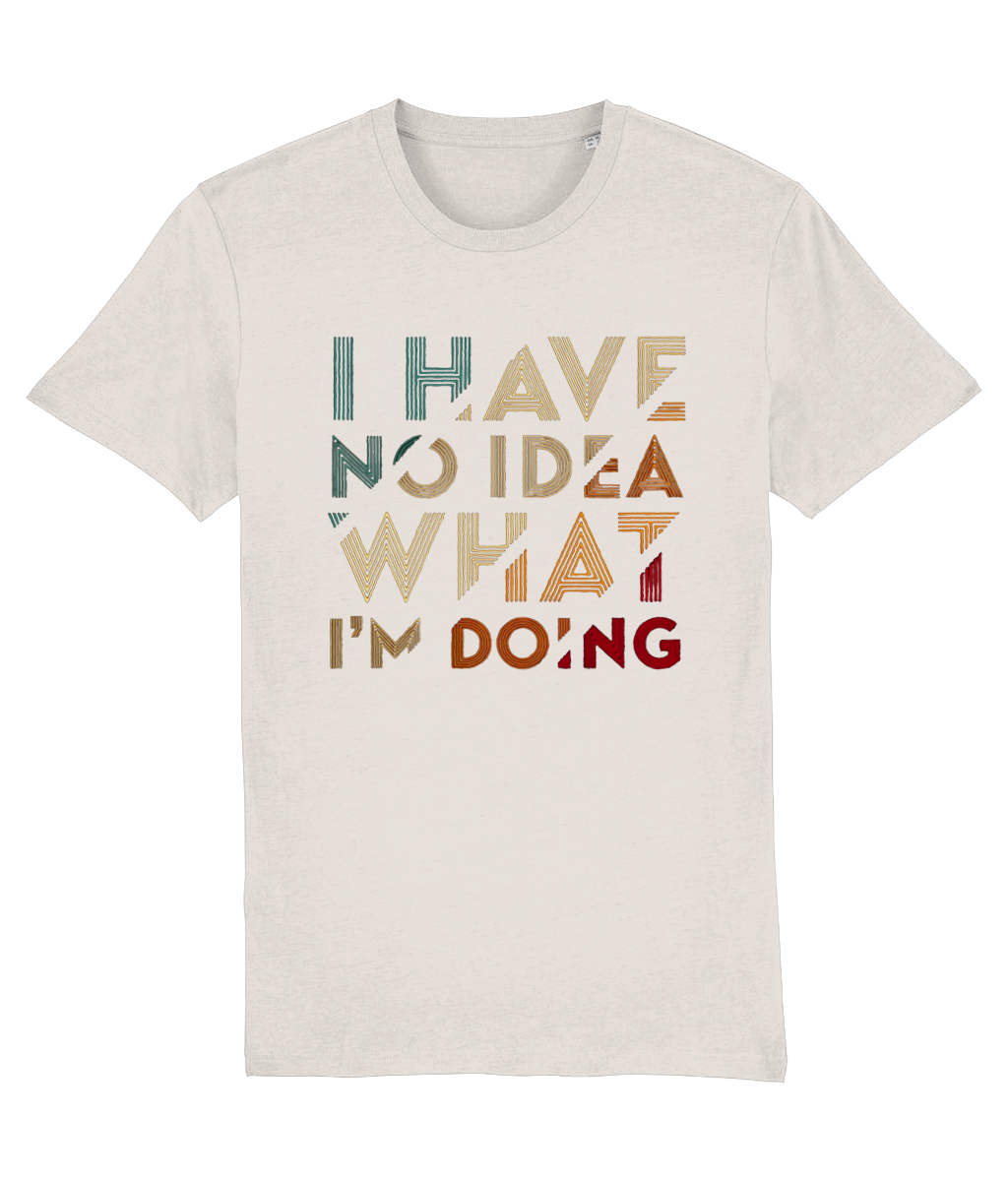 A light beige womens crewneck t-shirt featuring a retro-style typographic graphic that reads 'I HAVE NO IDEA WHAT I'M DOING' in stacked, distressed letters of varying colors including teal, tan, brown, and red.
