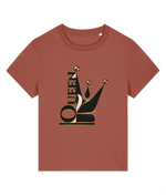 A short-sleeve crewneck womens t-shirt in a muted terracotta or rust color, featuring a large graphic on the chest of a black and gold crown with the word 'QUEEN' integrated vertically.