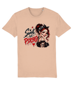 A light peach-beige short-sleeve womens t-shirt with a graphic print on the front. The graphic features a stylized illustration of a woman with red hair, a black bandana, and a skull, alongside the text 'Sweet but PSYCHO' in black and red lettering.