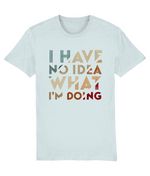 A light blue-gray womens crewneck t-shirt featuring a retro-style typographic graphic on the chest that reads 'I HAVE NO IDEA WHAT I'M DOING' in stacked, distressed letters of varying colors including teal, beige, orange, and red.