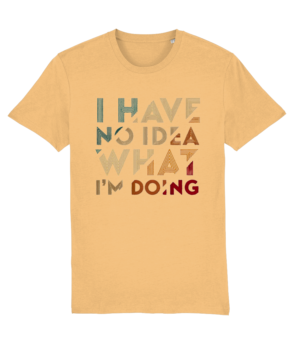 A short-sleeve womens crewneck t-shirt in a warm sandy beige color, featuring the text 'I HAVE NO IDEA WHAT I'M DOING' printed on the front in a retro, multi-colored distressed font.