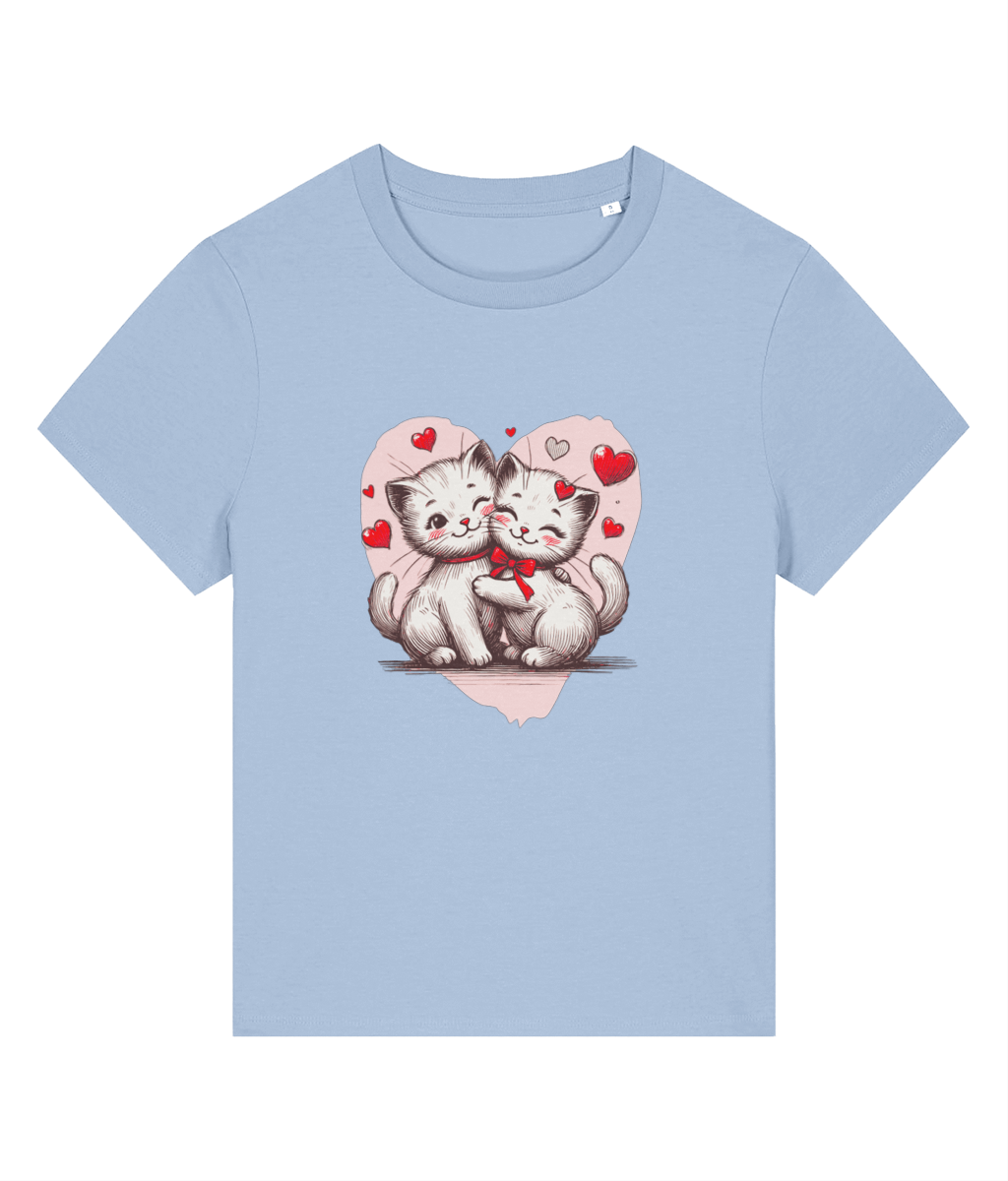 A womens light blue short-sleeve crewneck t-shirt featuring a cute graphic of two hugging white kittens inside a pink heart with small red hearts, displayed on a solid white background.