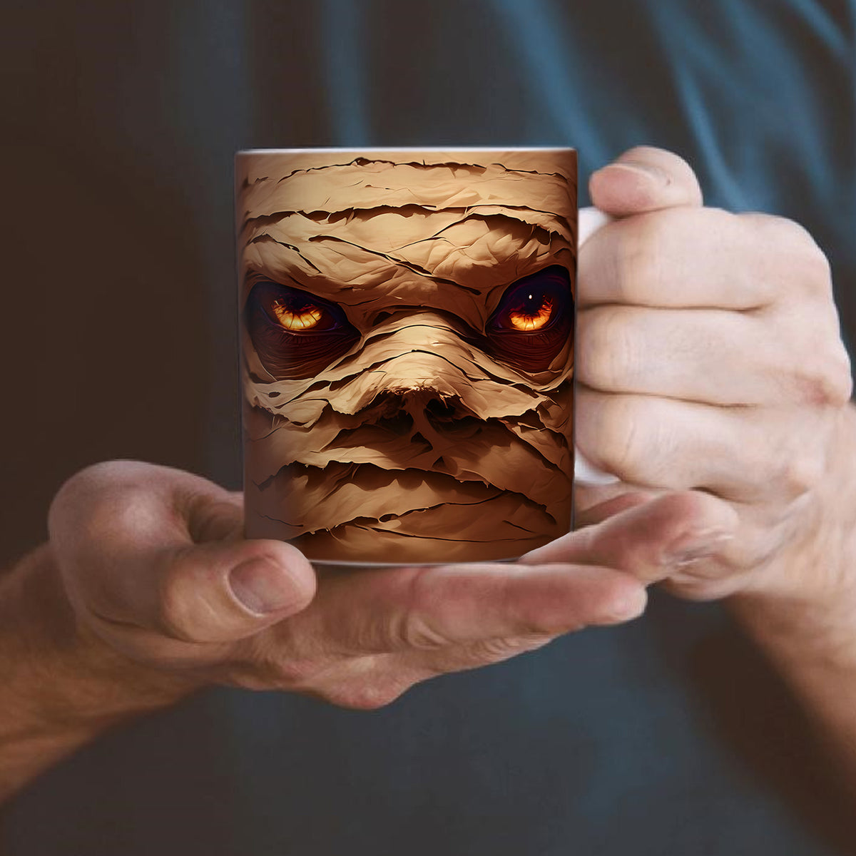 Coffee Mug with a mummy design held by two hands against a dark background