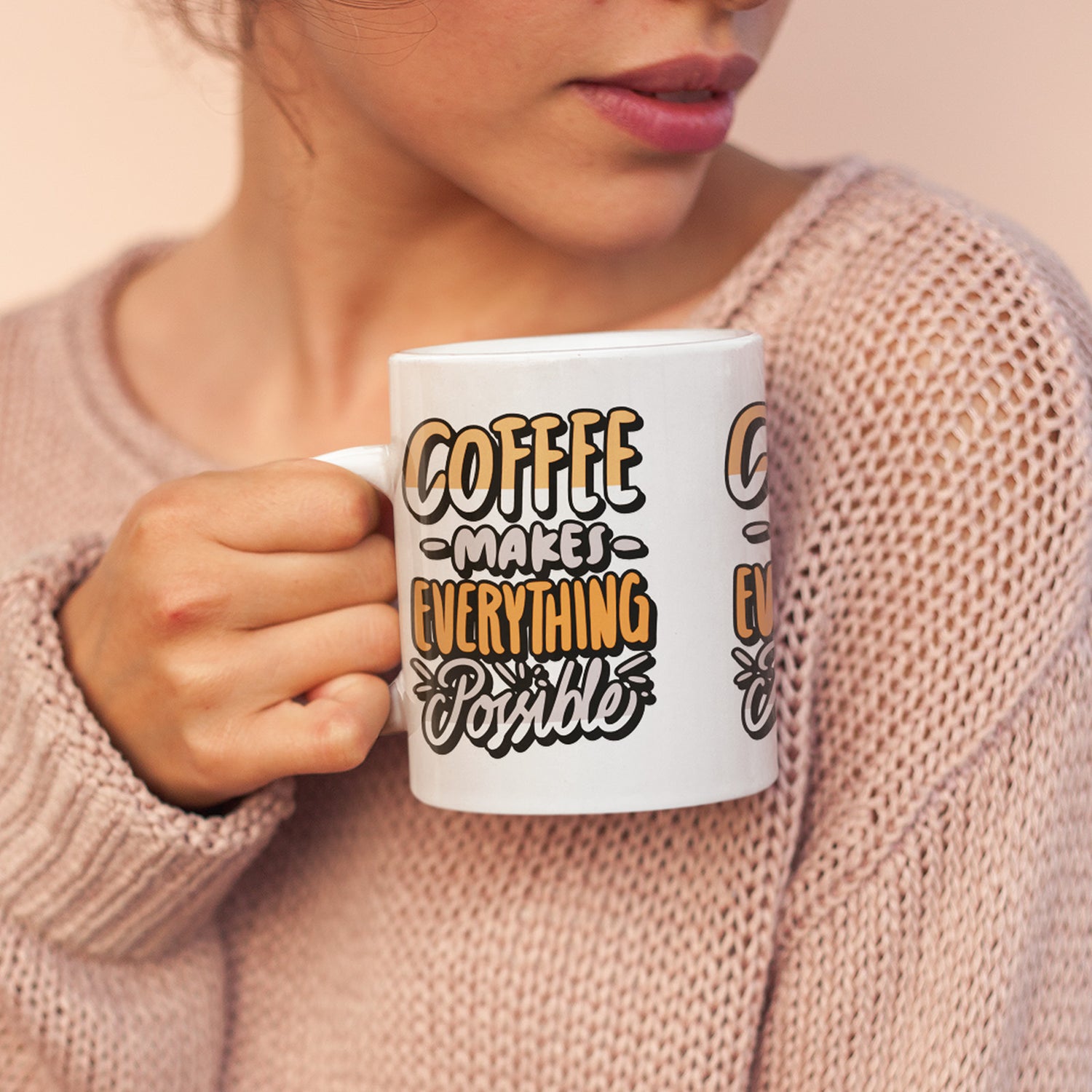 Person holding a mug with 'Coffee makes everything possible' text