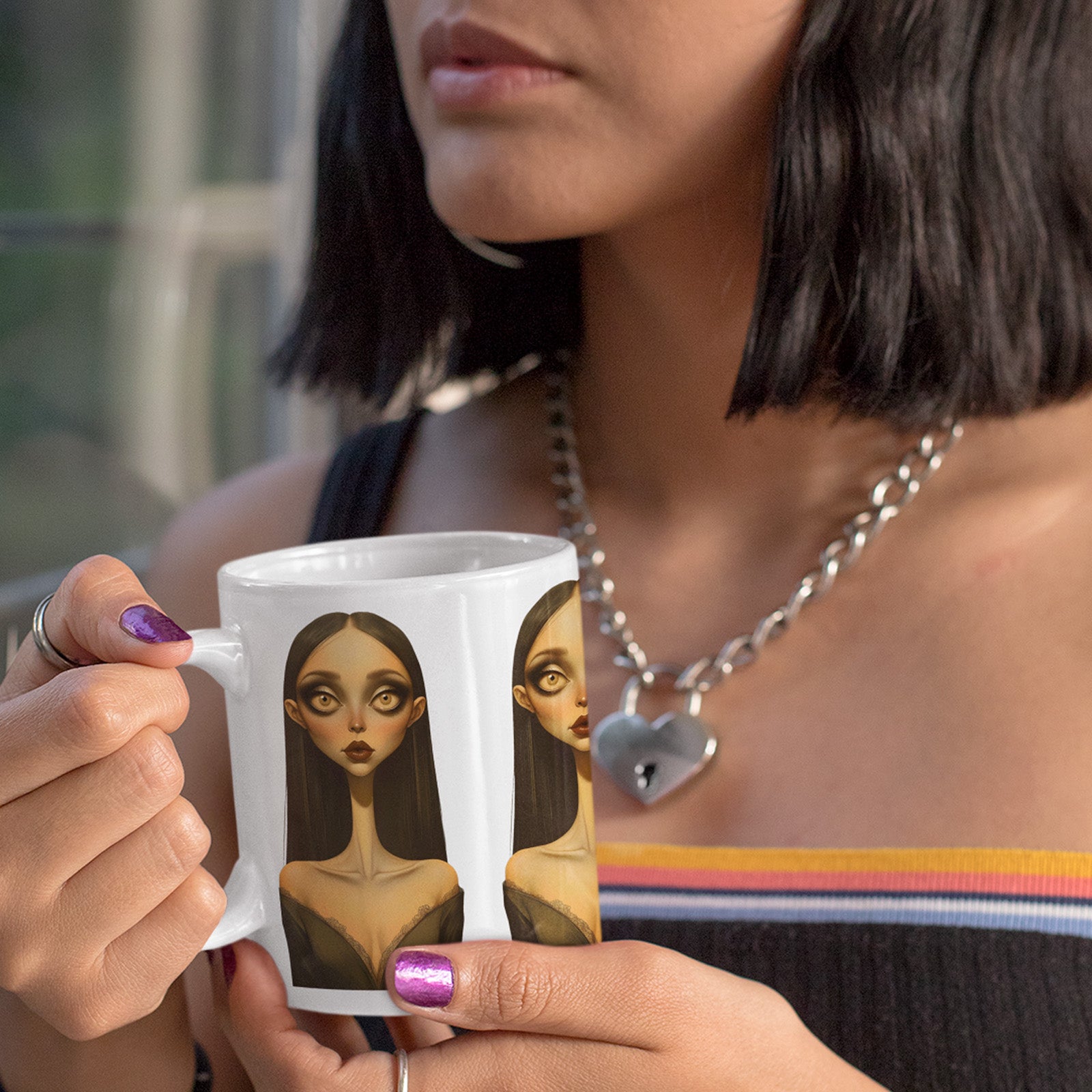 Person holding a mug with an artistic depiction of a woman's face.