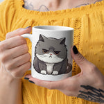 Person holding a mug with a cat illustration against a yellow background