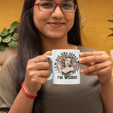 Person holding a mug with a graphic design and text.