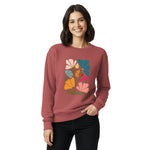 Woman wearing a maroon sweatshirt with a colorful floral design on a white background