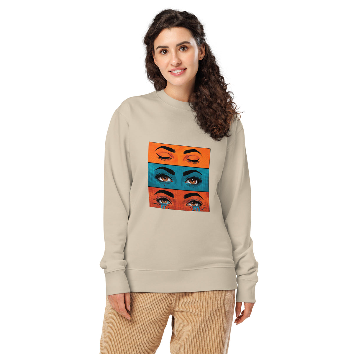 Woman wearing a beige sweatshirt with colorful eye design on a white background