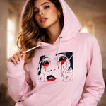 Woman wearing a pink hoodie with a graphic design on it.