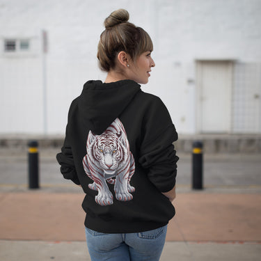 woman wearing a black hoodie with a white tiger design on the back, standing outdoors.