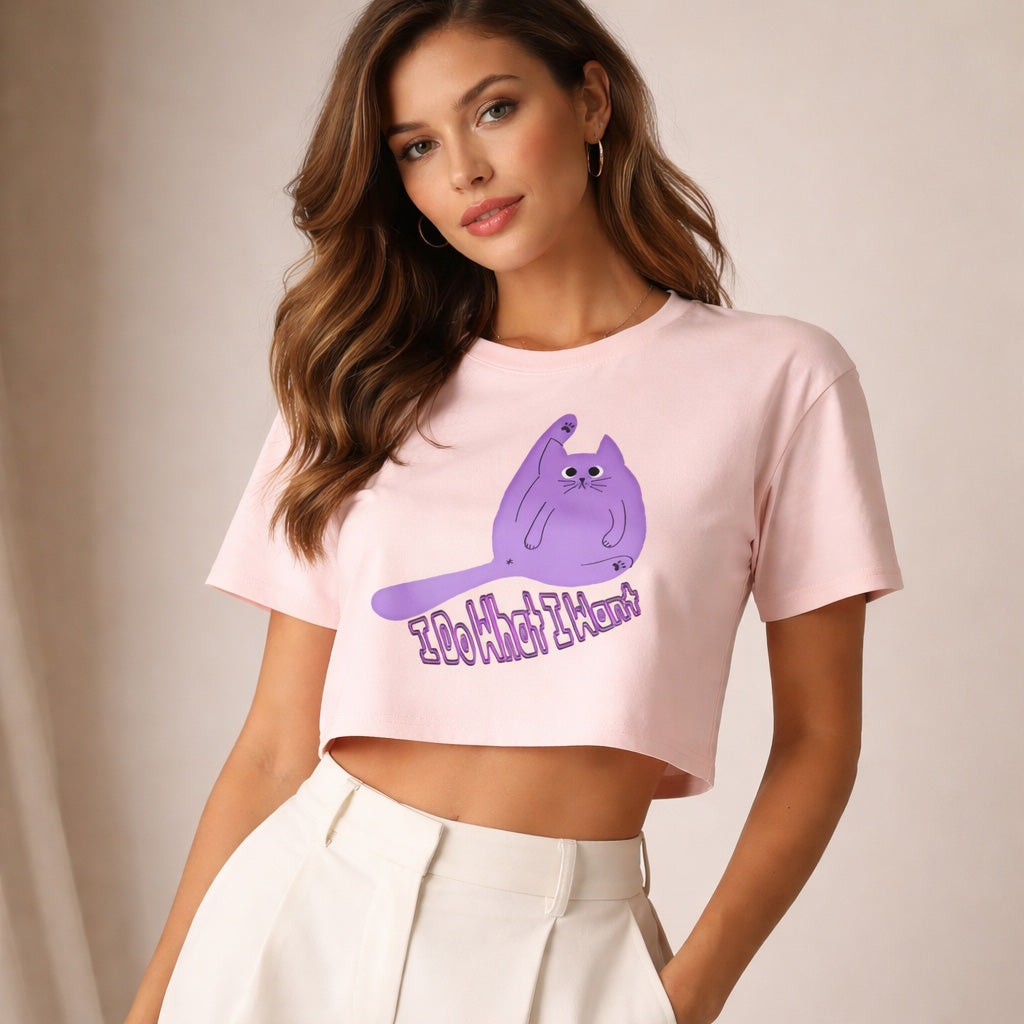 Woman wearing a pink crop top with a purple cat graphic and text on a plain background