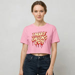 Woman wearing a pink crop t-shirt with 'I Make Onions Cry' text on a plain background