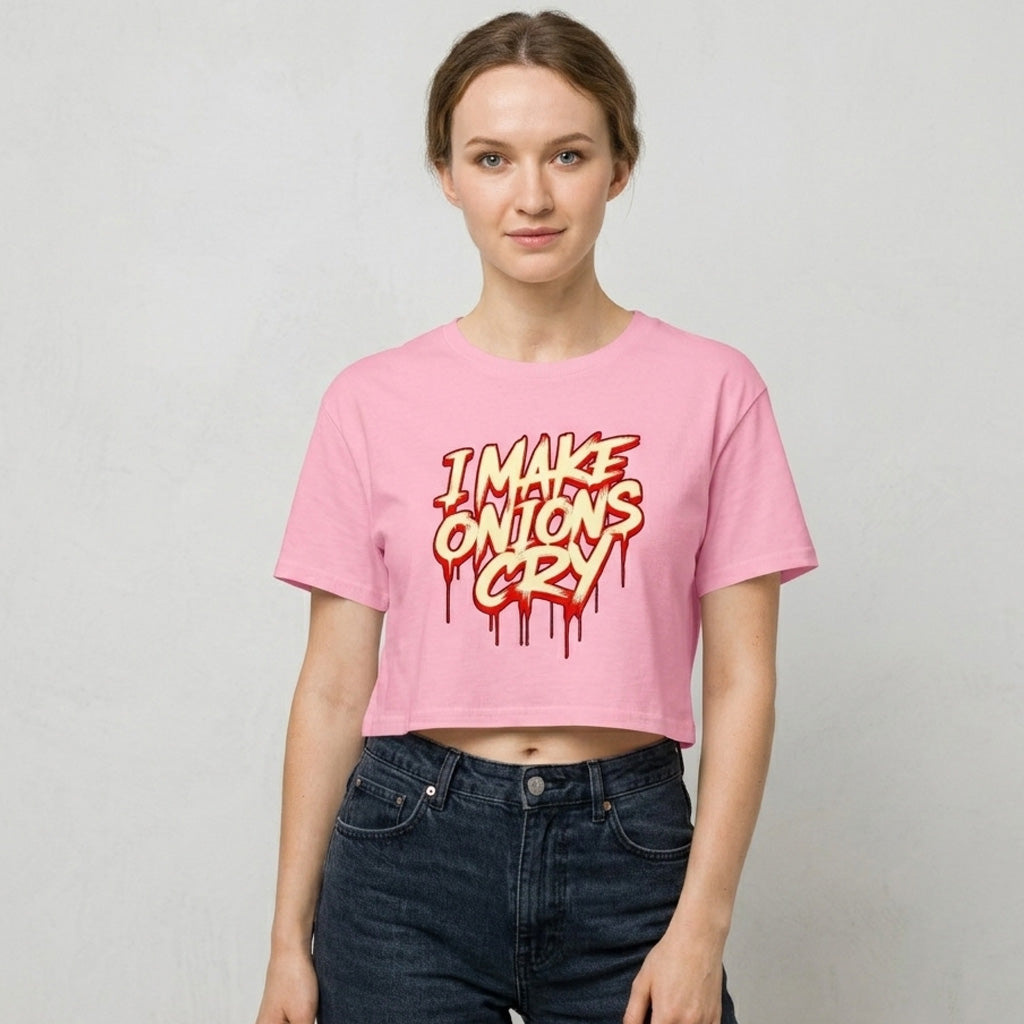 Woman wearing a pink crop t-shirt with 'I Make Onions Cry' text on a plain background