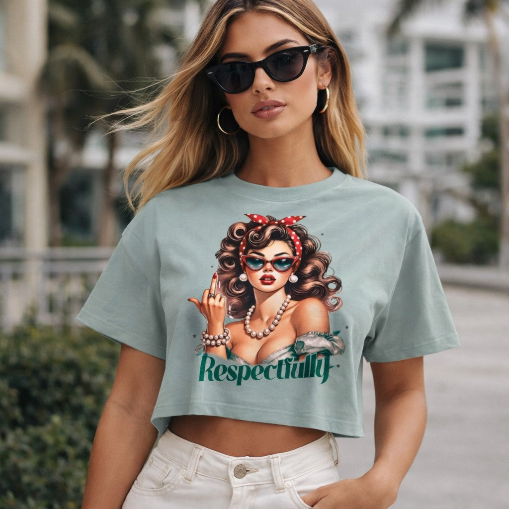 A woman wearing sunglasses and a crop top with a graphic of a retro-style woman, the word "Respectfully," and white high-waisted pants, stands outdoors with palm trees and buildings in the background.