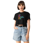 Woman wearing a black t-shirt with colorful text and denim shorts on a white background