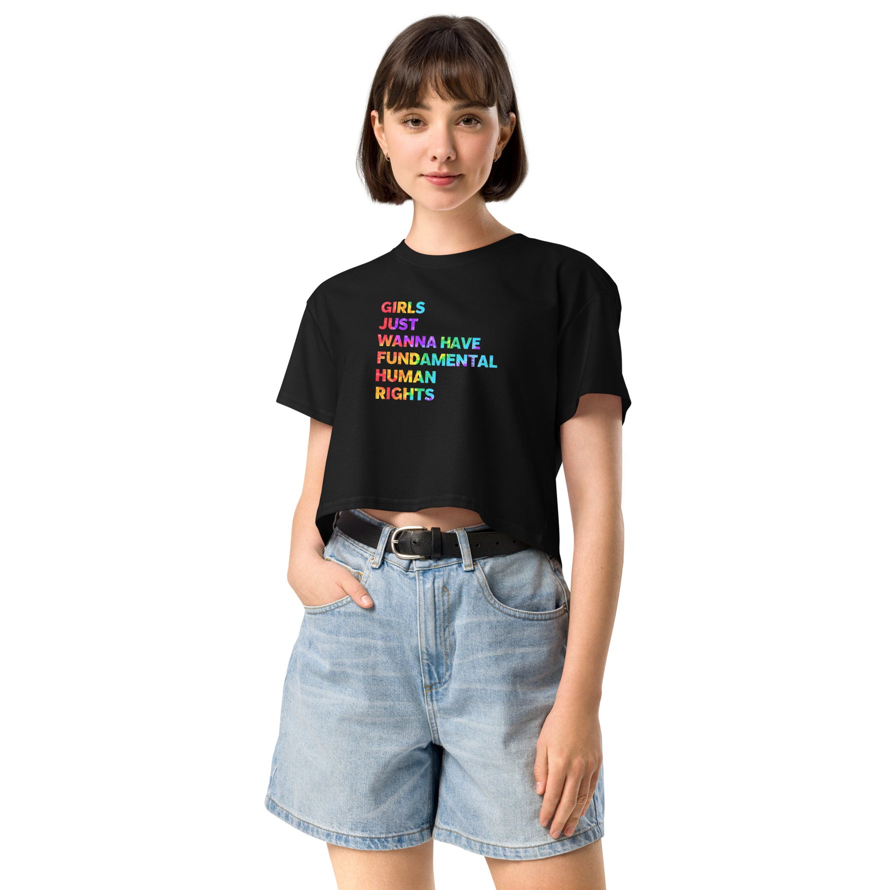 Woman wearing a black t-shirt with colorful text and denim shorts on a white background