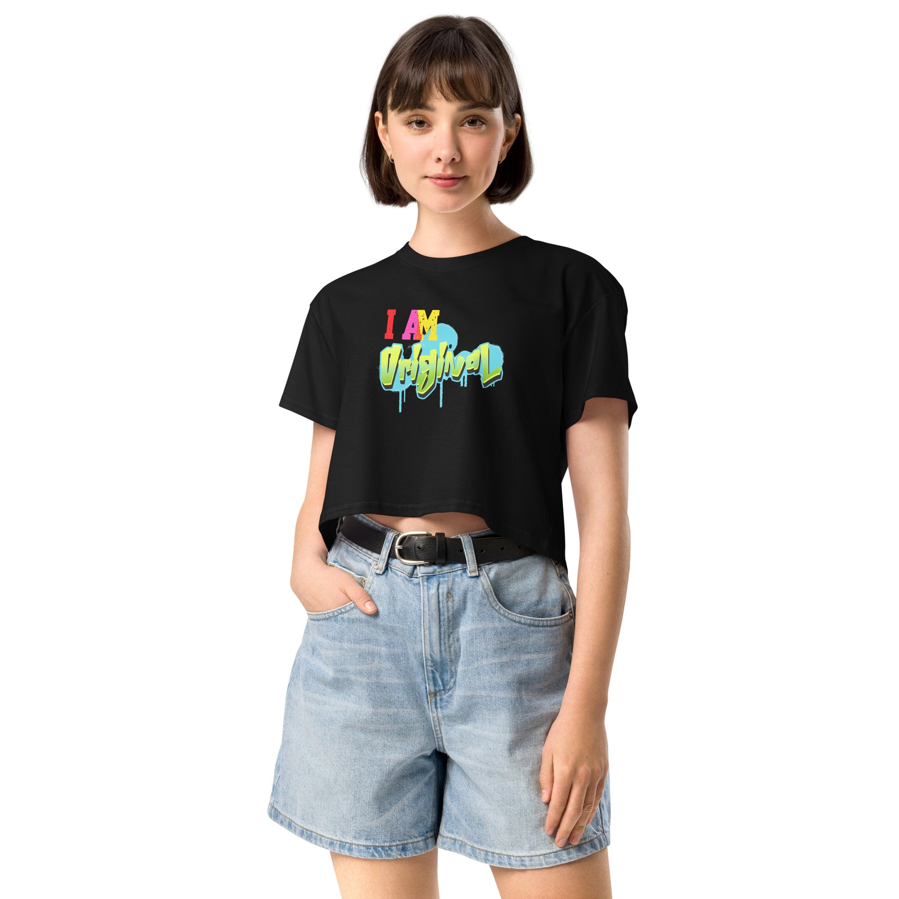 Woman wearing a black crop t-shirt with colorful text and denim shorts on a white background
