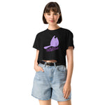 woman wearing a black t-shirt with a purple graphic and denim shorts on a white background