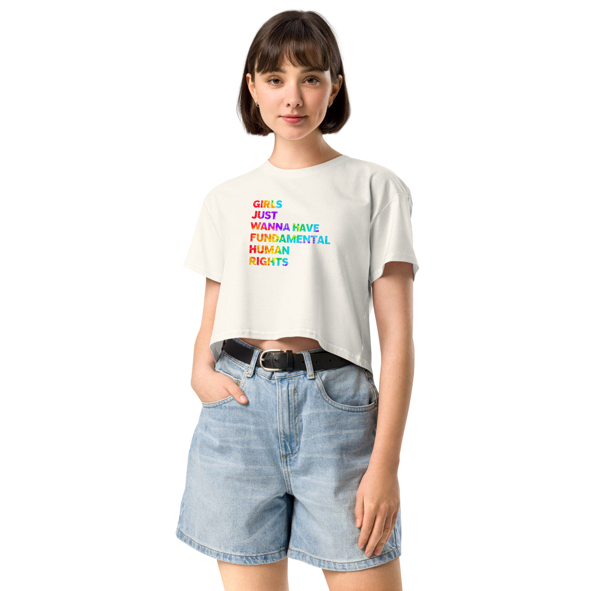 Woman wearing a white t-shirt with colorful text and denim shorts on a white background