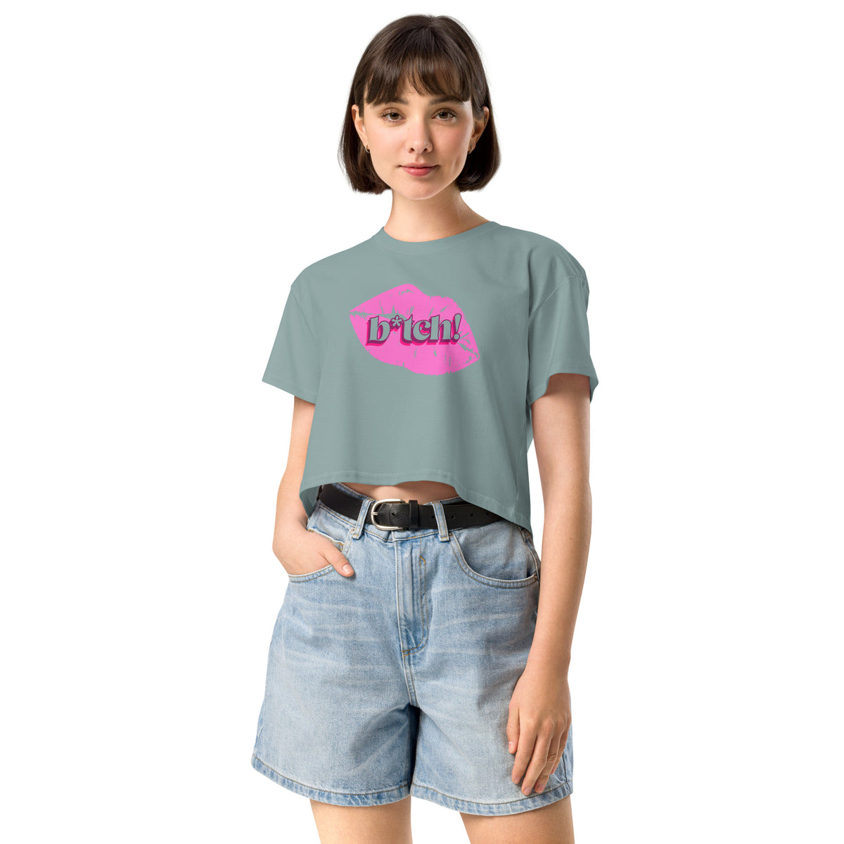woman wearing a light blue crop t-shirt with a graphic design and denim shorts on a white background