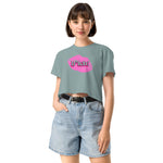 woman wearing a light blue crop t-shirt with a graphic design and denim shorts on a white background