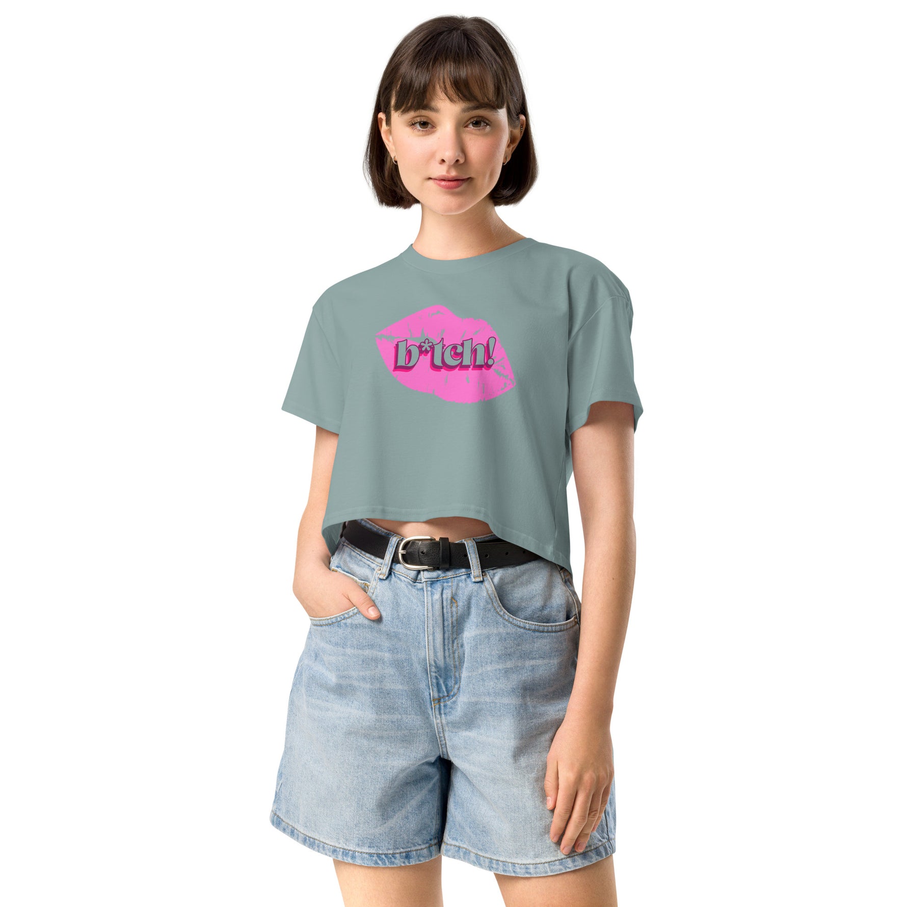 woman wearing a light blue crop t-shirt with a graphic design and denim shorts on a white background